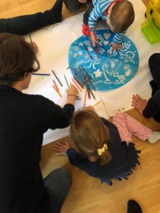 Kinder zeichnen unter Anleitung von Mutter